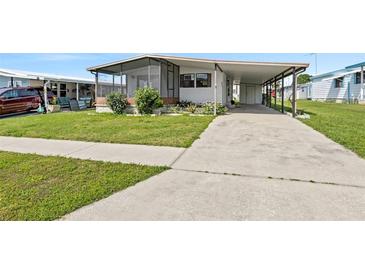 Single-wide manufactured home with carport and landscaped lawn at 3931 Chris Dr, Wesley Chapel, FL 33543