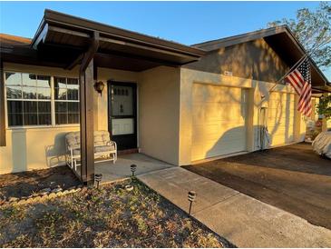 Quaint front exterior of a home with an attached garage, walkway, and covered entryway at 1567 Patton Dr # 1567, Dunedin, FL 34698