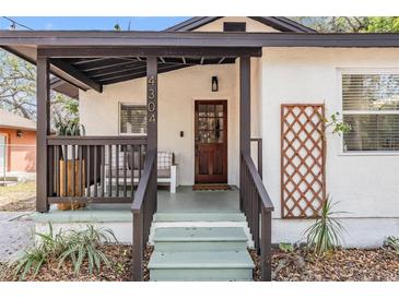 Inviting front porch with wood trim, seating, and decorative lattice, showcasing the home's curb appeal at 4304 W Laurel St, Tampa, FL 33607