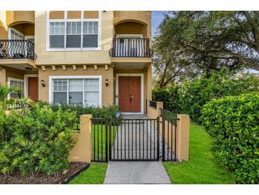 Charming two-story home featuring a front balcony, gated entrance, and lush landscaping at 111 N Albany Ave # 16, Tampa, FL 33606