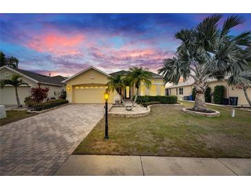 Charming single-story home with a well-manicured lawn and a brick driveway leading to a two-car garage at 1007 Emerald Dunes Dr, Sun City Center, FL 33573