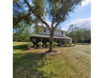 Two-story house with a screened porch and landscaping at 7117 Norway St, Webster, FL 33597