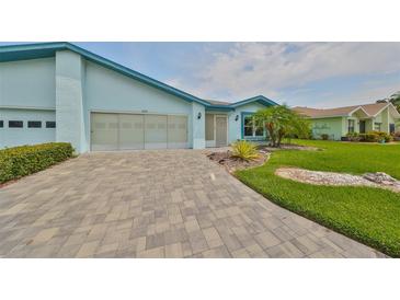 Light blue house with a paved driveway and manicured lawn at 2620 Locksley St # 261, Sun City Center, FL 33573
