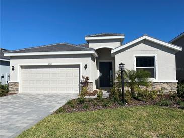 One-story home with a two-car garage and landscaping at 18021 Tavernside Trl, Bradenton, FL 34211