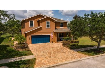 Two story house with blue garage door and manicured lawn at 3831 Evergreen Oaks Dr, Lutz, FL 33558