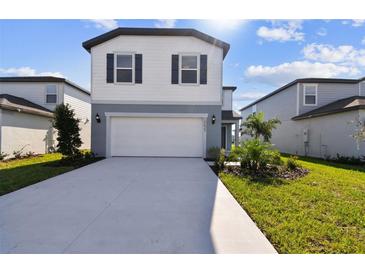 Two-story home with gray and white siding, two-car garage, and landscaped lawn at 10623 Hidden Banks Gln, Parrish, FL 34219