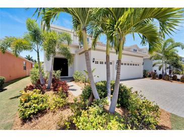 Inviting two-story home with lush landscaping, a paver driveway, and a two-car garage at 5243 Wishing Arch Dr, Apollo Beach, FL 33572