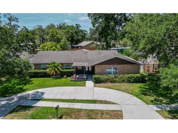 Aerial view of a single-story house with a circular driveway and landscaped yard at 1702 Blind Pond Ave, Lutz, FL 33549