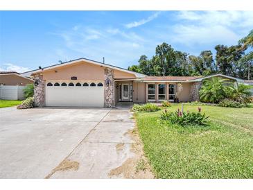 Charming home with a two-car garage, stone accents, and manicured lawn enhancing curb appeal in a lovely neighborhood at 2115 Seagull Dr, Clearwater, FL 33764