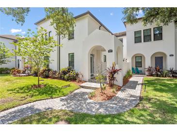 Charming two-story home featuring a stucco facade, arched entryway, and lush landscaping at 4606 W Fig St # 4, Tampa, FL 33609