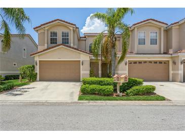 Two-story townhome with attached garage and manicured lawn at 10426 La Mirage Ct, Tampa, FL 33615