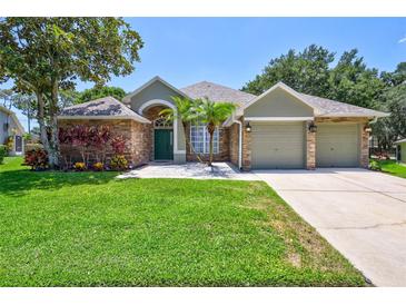 Beautiful two-story house with stone accents and a lush lawn at 805 Woodcarver Ln, Brandon, FL 33510