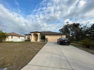 Single-story house with a brown roof, beige walls, and a two-car garage at 4458 Maverick St, North Port, FL 34288