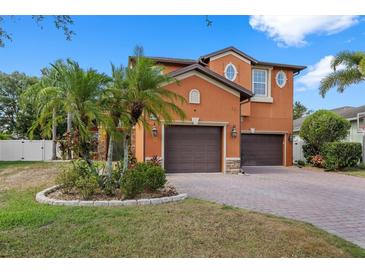 Two story house with brown garage doors and palm trees at 3823 65Th E Ave, Sarasota, FL 34243