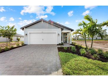 One-story home with gray siding, white garage door, and landscaped yard at 4717 Blue Star Ct, North Port, FL 34289