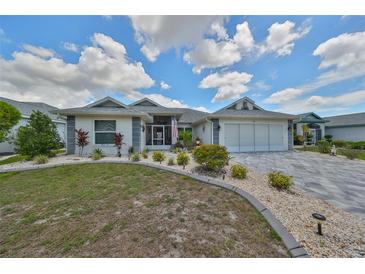 Single-story home with a landscaped yard and a three-car garage at 306 Caloosa Woods Ln, Sun City Center, FL 33573