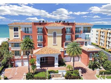 Beautiful condominium building with a red tile roof, palm trees, and ocean views at 16300 Gulf Blvd # 300B, Redington Beach, FL 33708