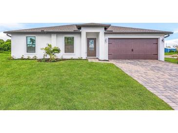 Newly built home features a white exterior, brown garage door, and manicured lawn at 4196 Sea Horse Ave, North Port, FL 34286