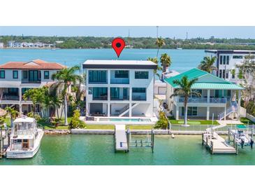 Modern waterfront home with a private dock, swimming pool, and panoramic water views at 831 Bay Point Dr, Madeira Beach, FL 33708