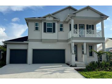 Two-story home featuring a light gray exterior, balcony, and a two-car garage at 4017 W Fig St, Tampa, FL 33609