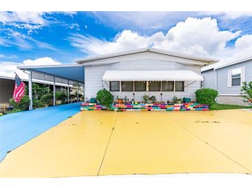 Mobile home with colorful landscaping and unique driveway at 7131 El Dewitt St, Zephyrhills, FL 33541