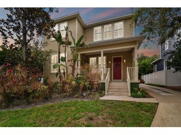 Two-story house with red door, front porch, and landscaped yard at 3104 W Fielder St, Tampa, FL 33611