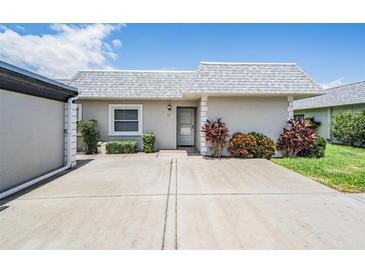 Light gray condo building with a private entrance and landscaping at 3332 Scorecard Dr, New Port Richey, FL 34655