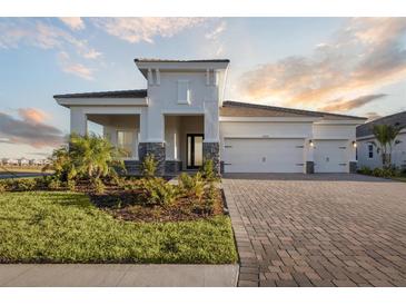 Two-story home with a three-car garage and paver driveway at 10426 Longmeadow Ave, Parrish, FL 34219