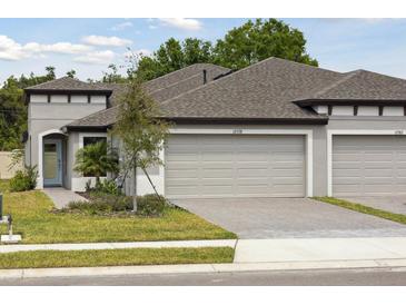 Charming single-story home featuring a two-car garage, manicured lawn, and beautiful landscaping at 12378 Oak Hill Way, Parrish, FL 34219