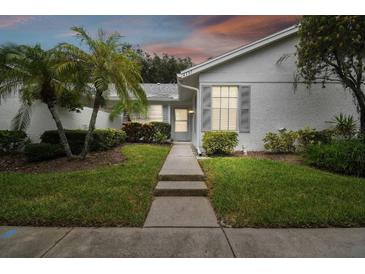Front view of charming villa with walkway and well-manicured lawn at 4137 Edgewood Dr, Holiday, FL 34691