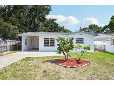 White house with a carport and a landscaped front yard at 5725 Newton S Ave, Gulfport, FL 33707