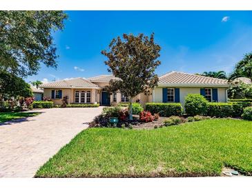 Single-story home with brick driveway and lush landscaping at 225 Pesaro Dr, North Venice, FL 34275