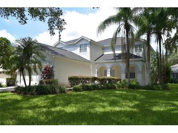 Two-story house with white siding, lush landscaping, and a large yard at 5308 Cedarshake Ln, Valrico, FL 33596