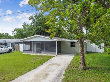 Charming ranch-style house with a screened porch and a spacious lawn at 7024 Filbert Ln, Tampa, FL 33637
