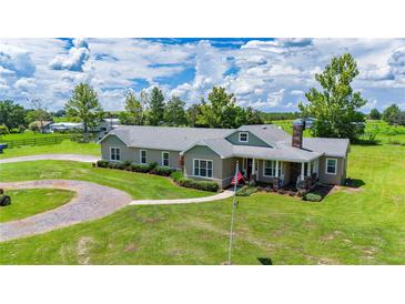 Charming single-story home features a sprawling lawn, inviting front porch, and a circular driveway at 36431 Florrie Mae Ln, Dade City, FL 33523