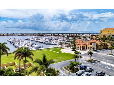 Stunning aerial view of the marina with lush green spaces and luxurious waterfront buildings on a sunny day at 130 Riviera Dunes Way # 403, Palmetto, FL 34221