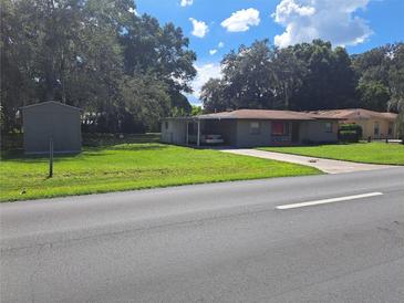 Image shows a ranch home with carport and storage shed at 5023 6Th St, Zephyrhills, FL 33542