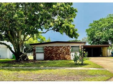 Brick ranch home with a carport and mature landscaping at 10921 Temple Ave, Seminole, FL 33772