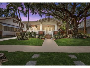 Charming bungalow with a large front porch, mature trees and well-maintained lawn at 2010 W Dekle Ave, Tampa, FL 33606