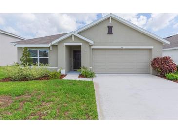 Single-story home with two-car garage and well maintained lawn at 810 Ace Outlaw Ave, Ruskin, FL 33570