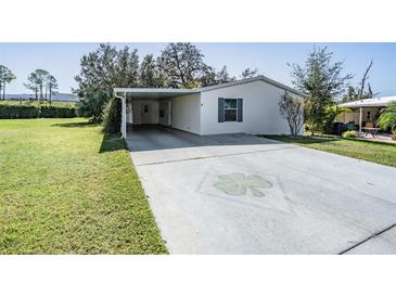 Single-wide mobile home with carport and clover driveway at 37700 Neukom Ave, Zephyrhills, FL 33541