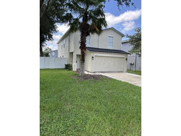 Two-story house with a two-car garage and a well-manicured lawn at 17350 Garden Heath Ct, Land O Lakes, FL 34638