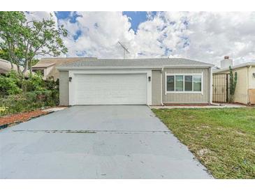 House exterior featuring a single-car garage and a well-maintained lawn at 4509 Tidal Pond Rd, New Port Richey, FL 34652