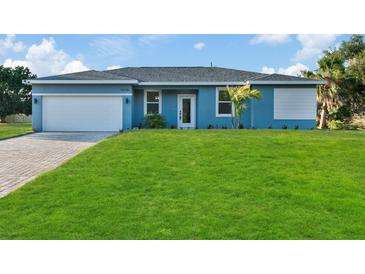 Single-story home with light blue exterior and two-car garage at 16443 Strauss Ave, Port Charlotte, FL 33954