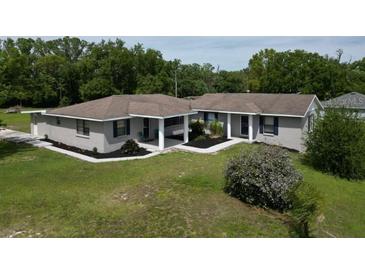 Charming single-story home featuring mature trees, a covered entry, and a well-maintained lawn at 10223 Us Highway 301, Dade City, FL 33525