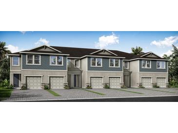 Three-story townhouses with attached garages and neutral colors at 31467 Woodland Race Loop, Wesley Chapel, FL 33545