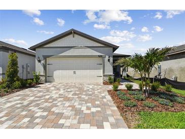 Modern home with a brick paver driveway and landscaping at 9210 Ballaster Pointe Loop, Parrish, FL 34219