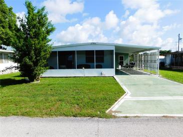 Mobile home with a screened porch and a paved driveway at 37303 8Th Ave, Zephyrhills, FL 33542