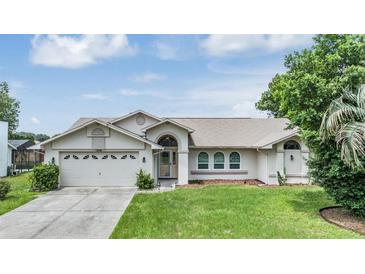 Exterior view of a single-story house with a two-car garage and a well-maintained lawn at 13199 Drysdale St, Spring Hill, FL 34609