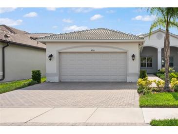 Two-car garage with paver driveway at 4906 Avila Lakes Dr, Wimauma, FL 33598